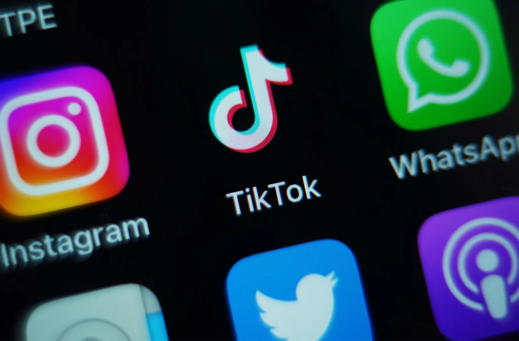 A close-up image of a smartphone screen displaying app icons, including TikTok, Instagram, Twitter, WhatsApp, and others.