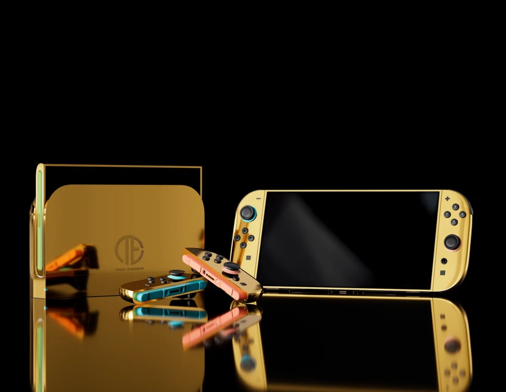 一款鍍金的任天堂NS2遊戲主機，旁邊擺放著藍色和橙色的手柄，背景為黑色。