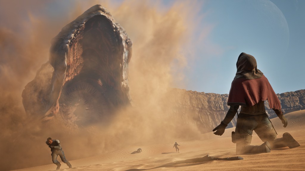 A dramatic scene from the game 'Dune: Awakening' showing characters in a desert landscape, with a giant sandworm emerging from the sand in the background.
