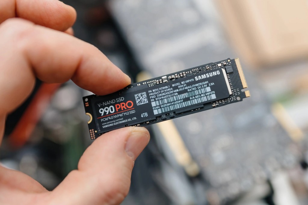 一名手持 Samsung 990 PRO 4TB NVMe M.2 SSD 的人，展示該固態硬碟的外觀與設計。