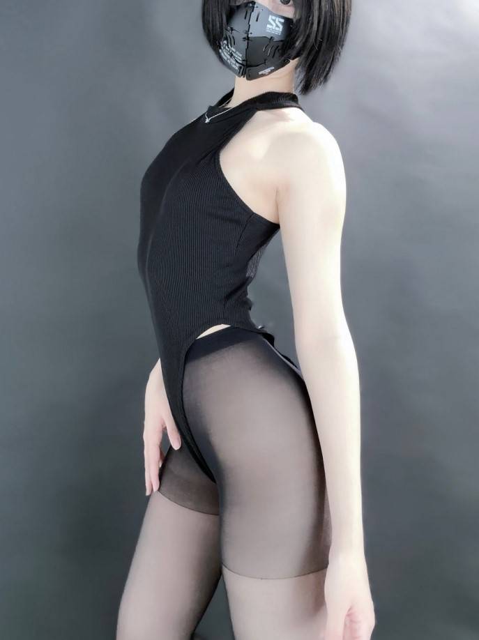 穿著黑色連身衣和絲襪的人物側面展示，配戴著黑色口罩，背景為淺色設計