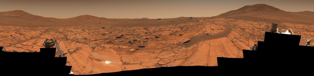 NASA毅力號火星車拍攝的火星全景照片，展現異常晴朗的藍色天空、沙丘上的岩石及遠處山丘的壯觀景色，該圖片由96張影像拼接而成，展示了火星的獨特地貌。