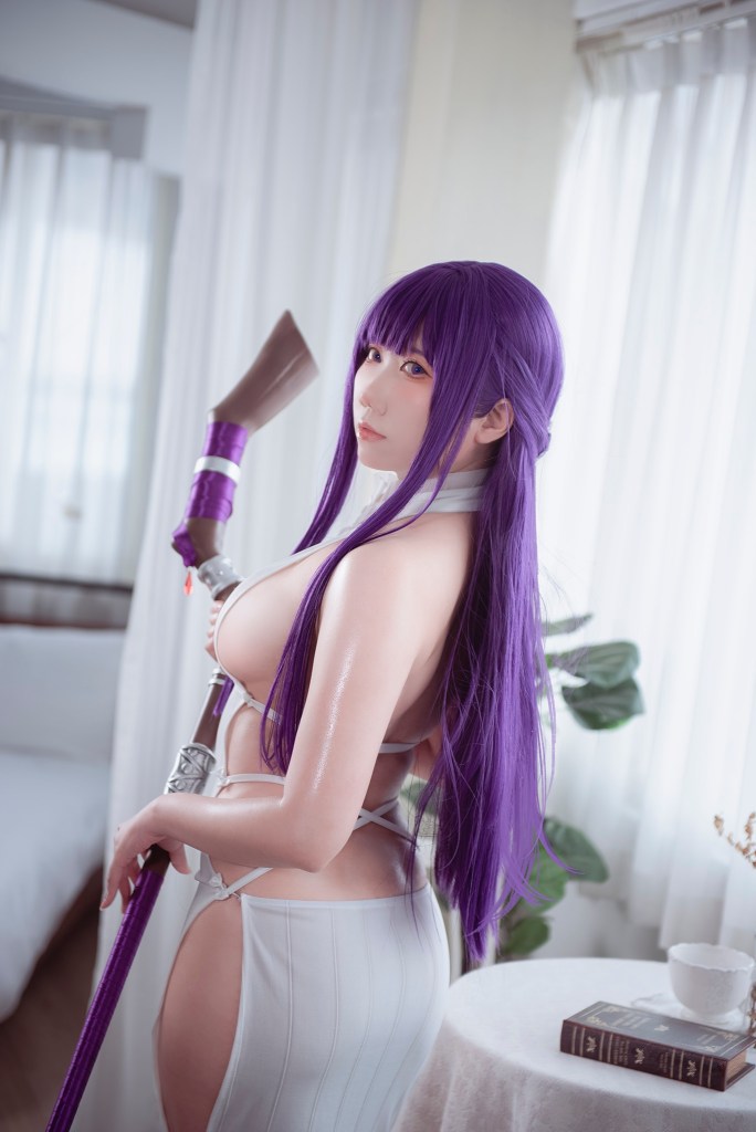 A person in a purple wig and revealing outfit poses with a staff, showcasing a confident expression. The background features soft natural light filtering through curtains.