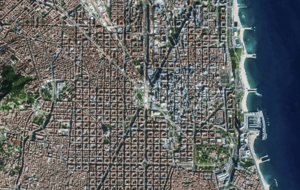 衛星圖像顯示巴塞隆納的擴展區,特徵是規整的網格街區和城市規劃特色。