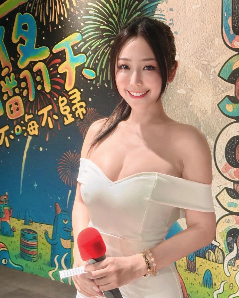 一位穿著白色晚禮服的女性，微笑著站在色彩繽紛的牆面前，手持紅色麥克風。